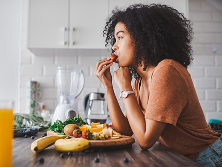 woman eating fruit in the kitchen