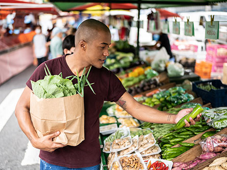man picking out produce at farmers market