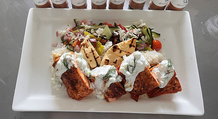 Mediterranean spiced salmon with yogurt and vegetables on a plate