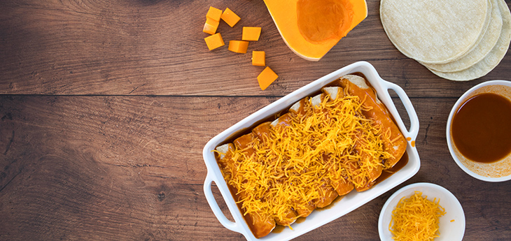 Butternut squash enchiladas on a wooden background