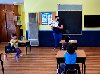 teacher leads small classroom with kids wearing masks