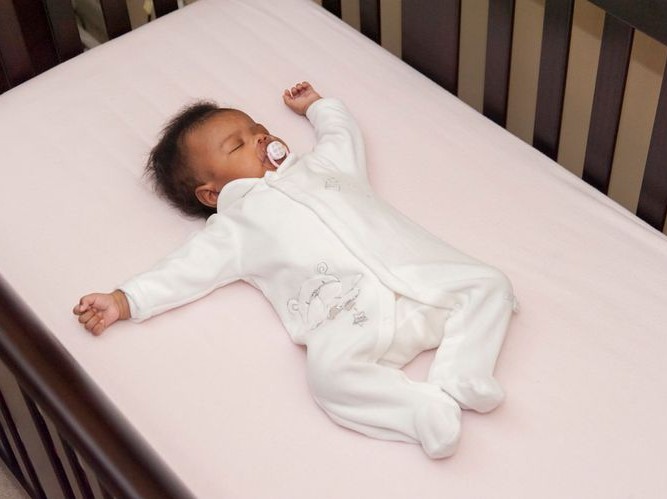 baby sleeping alone, on back, in crib