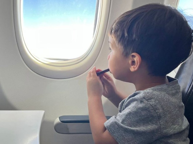 kid looking out plane window 