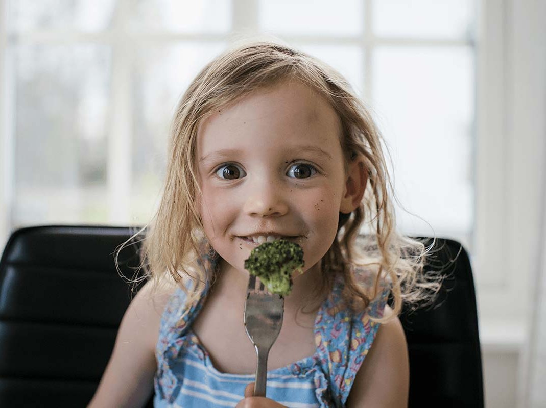 girl eating broccoli
