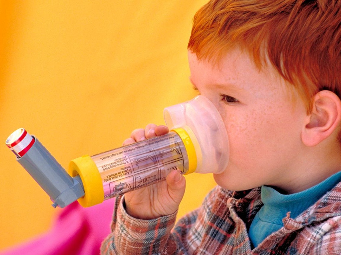 kid using inhaler with spacer