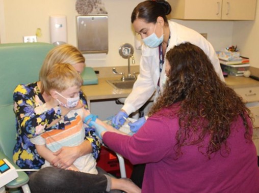 child getting a blood draw on parents lap