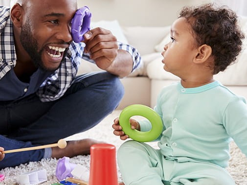 dad playing with child on floor
