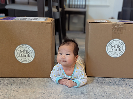 Baby with milk bank donation boxes