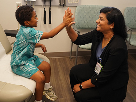 Savon and pediatric epileptologist Trishna Kantamneni high-five during a clinic visit.