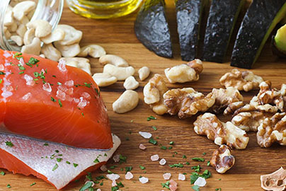 Raw salmon sitting on cutting board with garlic and walnuts