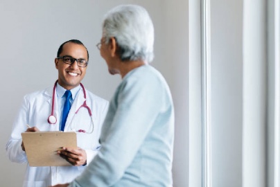 Latino doctor speaking with an older, female patient