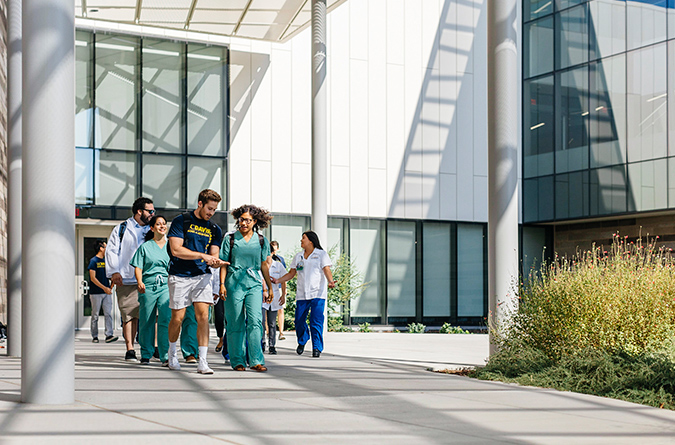 Medical students walking in a courtyard.