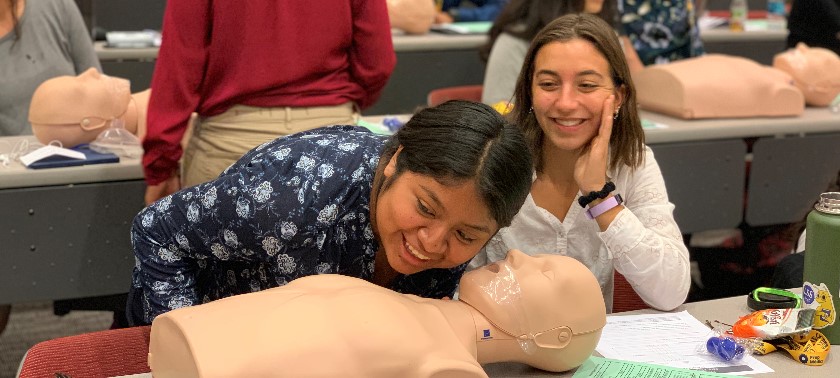 students practice performing CPR 