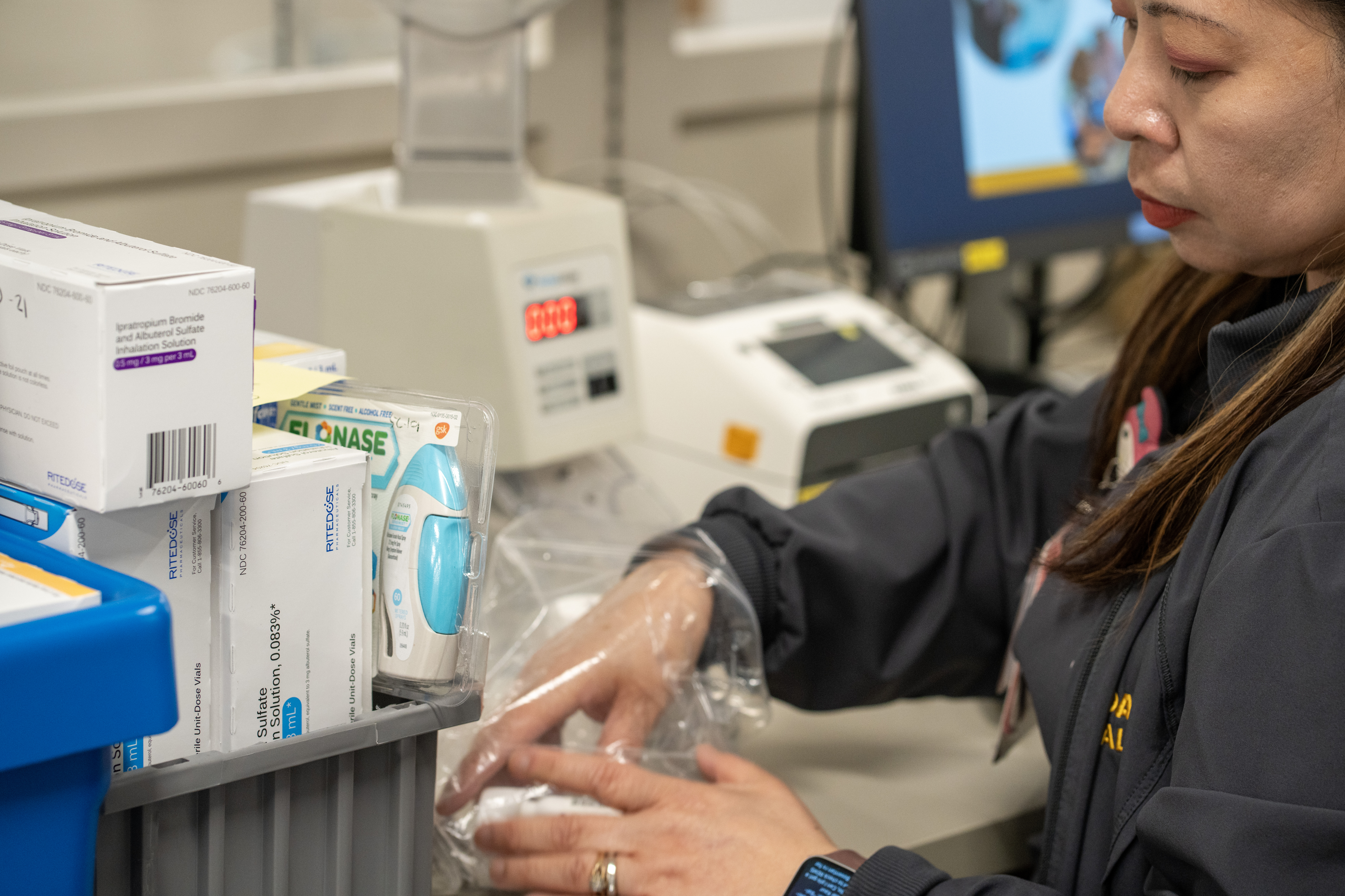 Close up of an employee stocking medications at the pharmacy shared services center