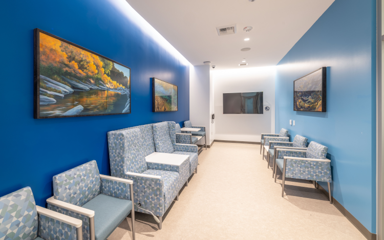 Interior of the 48X Complex Level 1 23-Hour Observation Waiting Room with the Dreaming River, Blaze of Glory and Emerald Pools art pieces hanging on the wall 