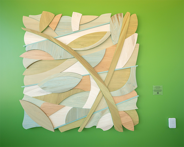 Close up of the Leaf & Branch art piece on a green wall.