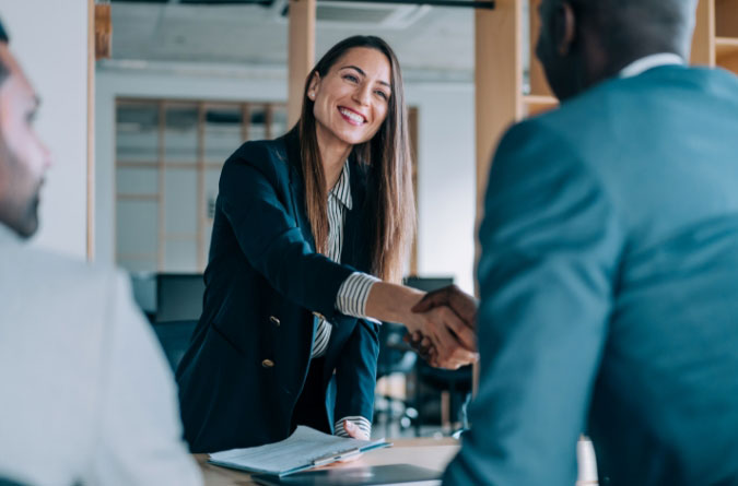 woman and man shaking hands in office setting