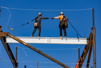 Photo of two 48x workers fist bumping on top of building
