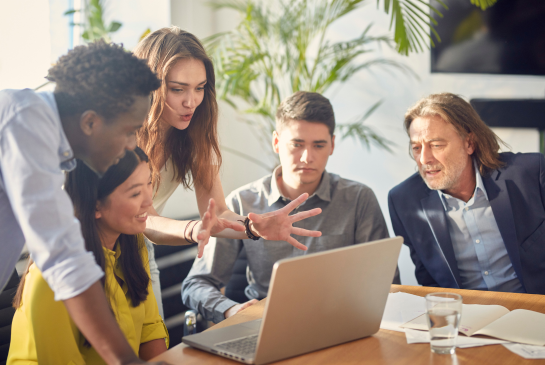 group of researchers around a computer in discussion