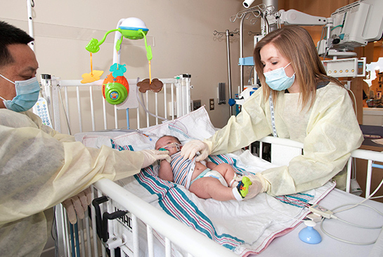 Healthcare workers helping an infant