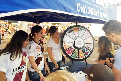 UC Davis Health workers at an information booth playing a game with visitors.