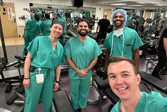 A group of doctors taking a selfie in a gym.