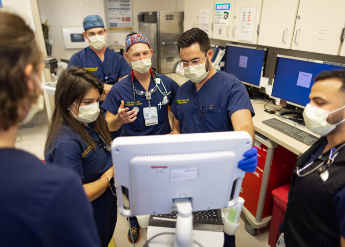 group of residents and faculty looking at computer