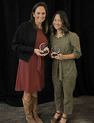 Pediatric surgery nurse practice manager Amy Powne holding her award next to another award winner.