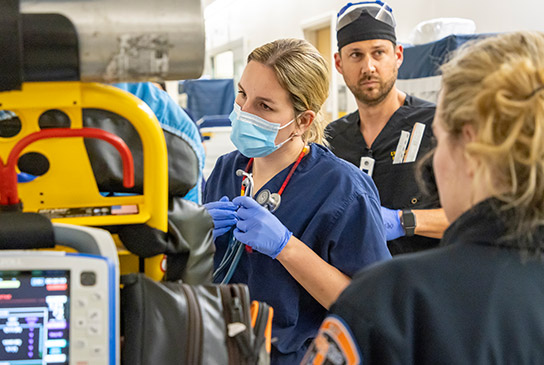 A doctor wearing gloves and a mask in the emergency department