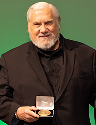 Kenneth W. Kizer holding an award