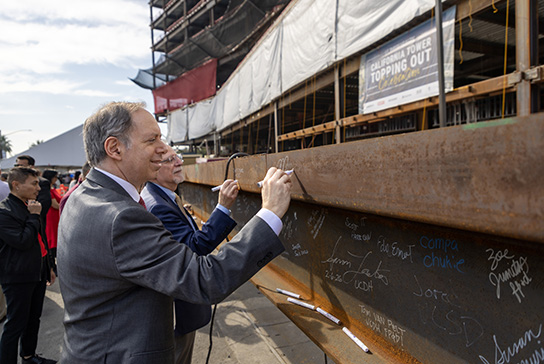 Vice Chancellor of Human Health Sciences Mark Rosenblatt signing the California Tower beam.