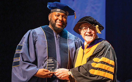 Aron King holding an award next to Stephen Cavanagh, dean of the Betty Irene Moore School of Nursing.