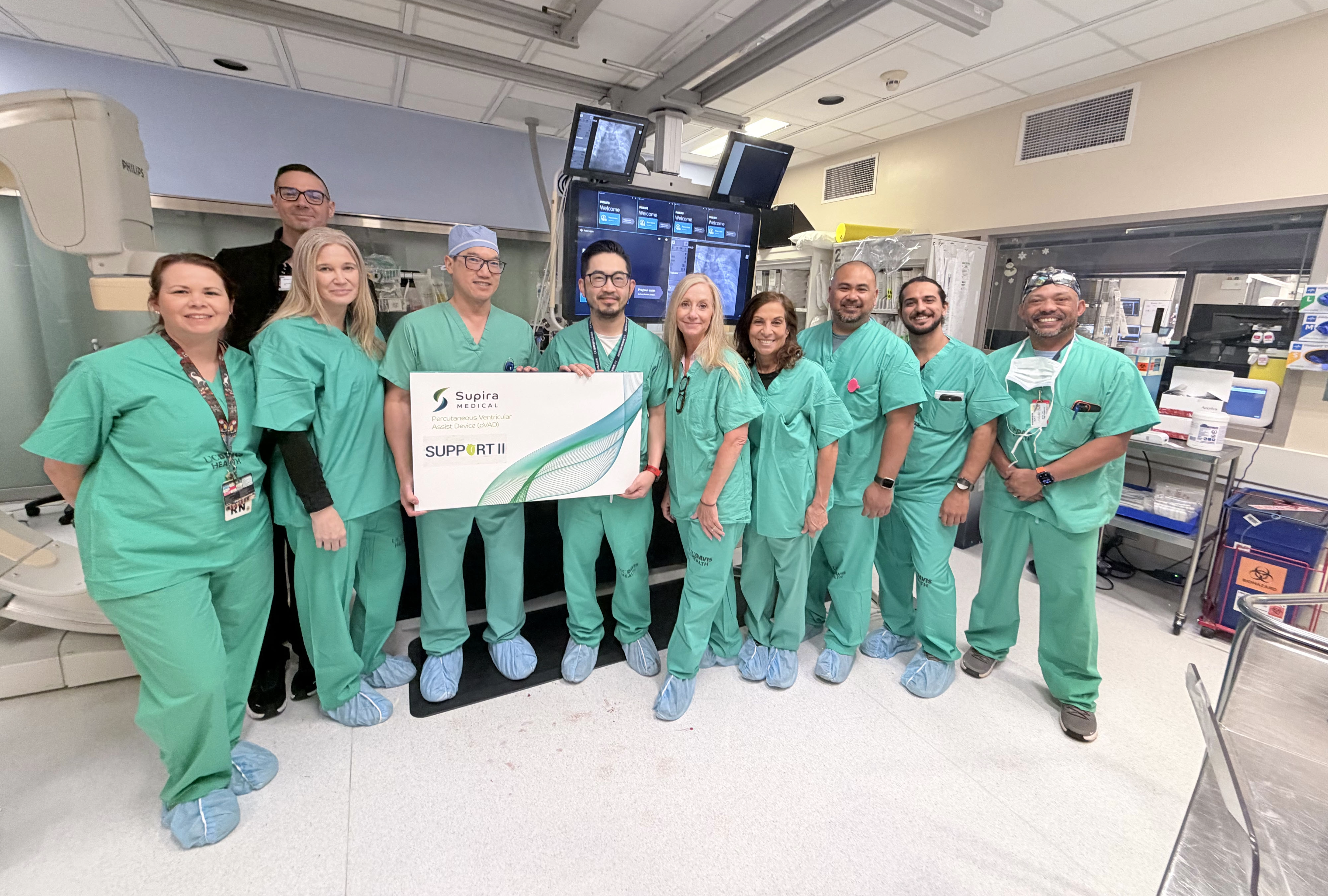 Heart team smiling holding clinical trial poster.
