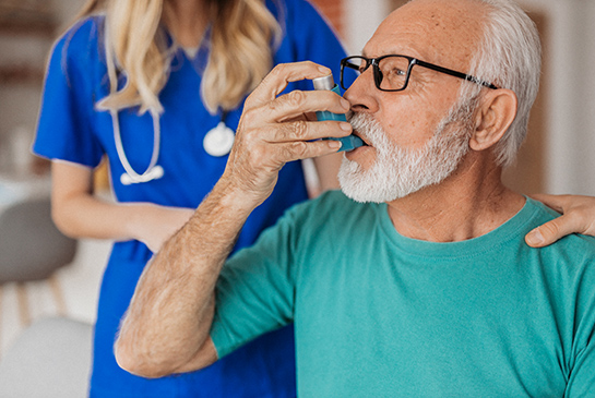 Man uses an inhaler near a nurse