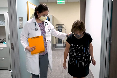 Healthcare provider observing how a patient walks down a hallway.