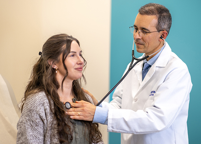El doctor Víctor Baquero, médico de atención primaria, utilizando un estetoscopio para escuchar el corazón de un paciente.