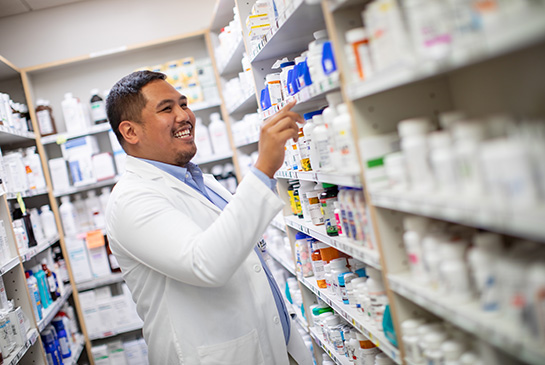 pharmacist with pharmacy shelves