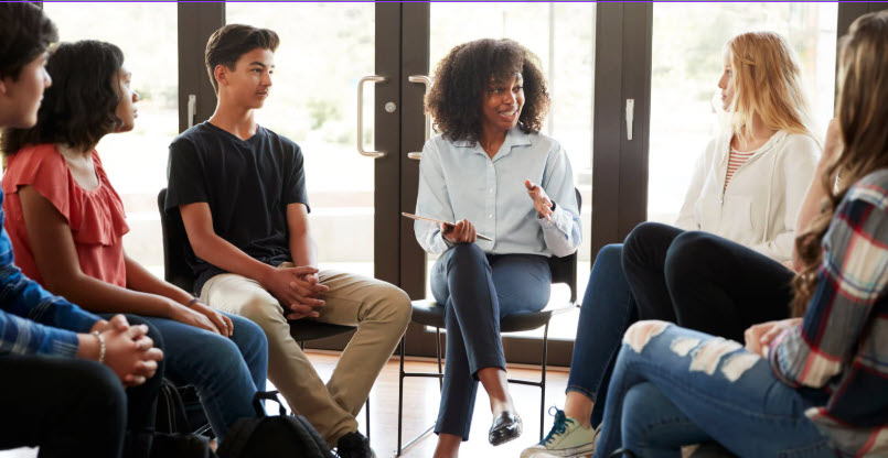 a group meets around a classroom table