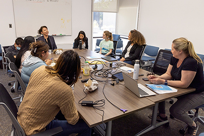 Colleagues gathered around a table having a discussion.