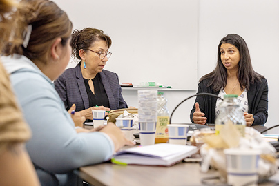 A group of people gathered around a table having a discussion.