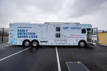 a large recreational vehicle in a parking lot with the logo "early detection saves lives" visible in large blue letters on the side