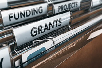 A cabinet of brown folders labeled funding, grants and projects