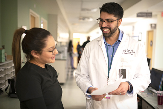 Dr. Mustafa Ansari talking with staff member in clinic hallway