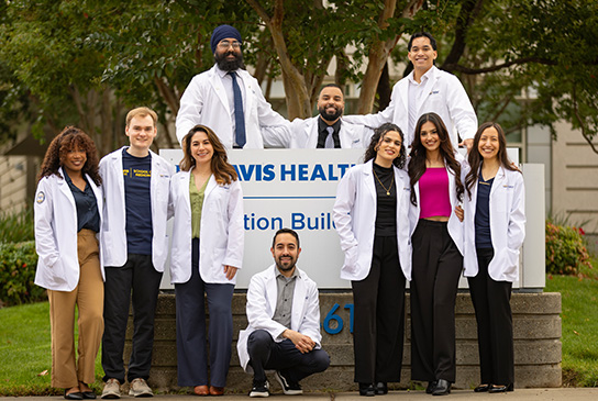 Group of medical students in front of UC Davis School of Medicine education building sign