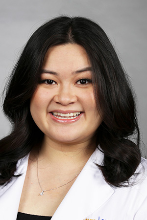 Portrait of medical student An Tran Soto in white coat and smiling