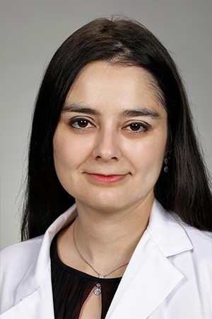 Portrait of medical student Miriam Gonzalez in white coat and smiling