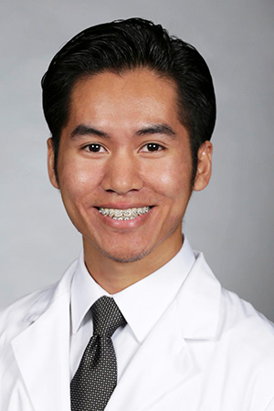 Portrait of medical student David Yang in white coat and smiling