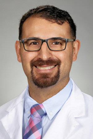 Portrait of medical student Michael Parr in white coat and smiling