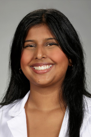Portrait of medical student Mehikpreet Sindhu in white coat and smiling