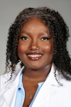 Portrait of medical student Omoyele Oyesanya in white coat and smiling